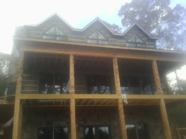 Dormers and porch framing on a large log home under construction — Roof Coating work by our crew in Cascade